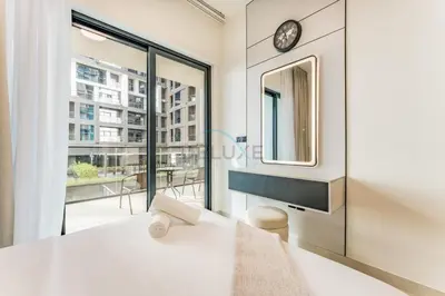 a room with a large window and a clock on the wall at Spacious Balcony Overlooking the Burj Khalifa and City Skyline, Near Bus Station, Quick Drive from Downtown Top Attractions, Binghatti Canal, Business Bay by Deluxe Holiday Homes in Dubai