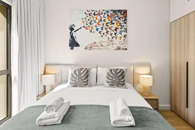 a bedroom with a bed with white towels on it at Modern and family friendly 1 bed in Dubai