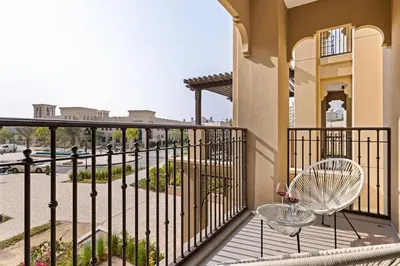 a balcony with two chairs and a view of a street at Modern and family friendly 1 bed in Dubai