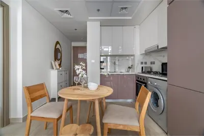 a kitchen with a table and chairs and a washing machine at GuestReady - Contemporary elegance in Dubai in Dubai
