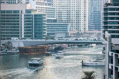 a bridge over a river with boats in a city at Marina Waterfront Bliss - Steps from Promenade in Dubai