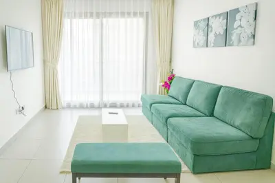 a living room with a green couch and a table at New Large 2BR Apt Sleeps 10 Adults with Pool Gym Parking and Wifi in Dubai