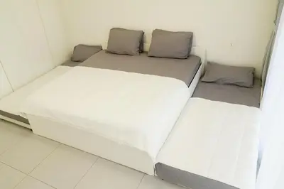 two beds in a small room with white walls at New Large 2BR Apt Sleeps 10 Adults with Pool Gym Parking and Wifi in Dubai
