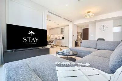 a living room with a couch and a tv at STAY BY LATINEM Luxury 1BR Holiday Home CVG 604 Near Downtown in Dubai
