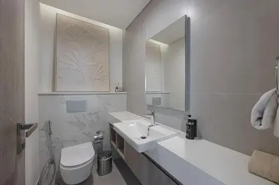 a bathroom with a sink and a toilet and a mirror at Daniels 2BR at Liv Marina with Marina View in Dubai