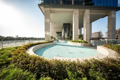 a swimming pool in front of a building at Luxury 1 Bedroom Canalfront Apartment with Burj Khalifa Views from Resort-Style Pool - Walk to Jumeirah Beach in Dubai