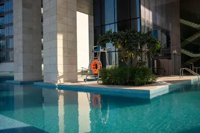 a building with a swimming pool in front of a building at Luxury 1 Bedroom Canalfront Apartment with Burj Khalifa Views from Resort-Style Pool - Walk to Jumeirah Beach in Dubai