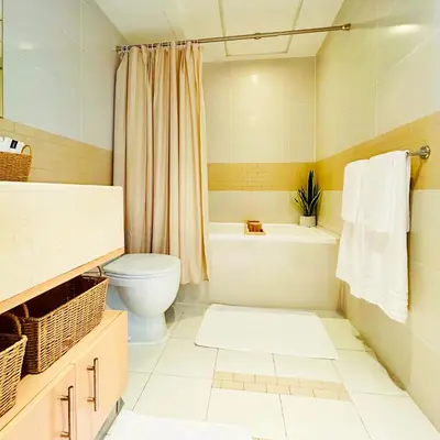 a bathroom with a toilet and a tub and a sink at Marina Oasis JBR Beach in Dubai