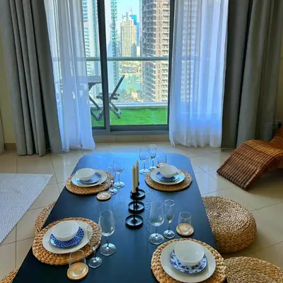 a blue table with glasses and plates on it at Marina Oasis JBR Beach in Dubai