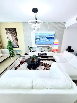 a living room with a white couch and a flat screen tv at WAHA WOW Bed space Available in Luxury Apartment in Sabkhah