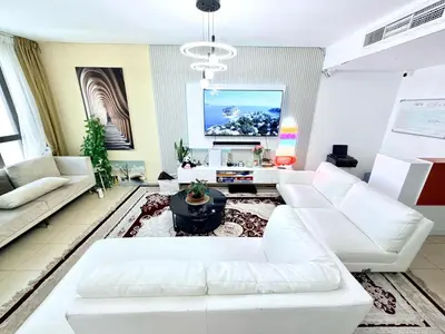 a living room with white furniture and a tv at WAHA WOW Bed space Available in Luxury Apartment in Sabkhah
