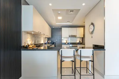 a kitchen with a bar with two stools at PVH - Iconic Waterfront Escape - Luxury 2BR with Sea Views - DUBAI MARINA in Dubai