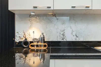 a kitchen with white cabinets and a black counter top at PVH - Iconic Waterfront Escape - Luxury 2BR with Sea Views - DUBAI MARINA in Dubai