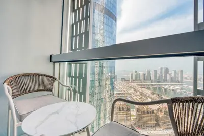 a balcony with a table and chairs and a view of a city at PVH - Iconic Waterfront Escape - Luxury 2BR with Sea Views - DUBAI MARINA in Dubai