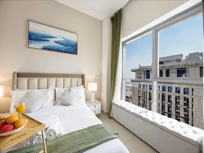 a bedroom with a bed and a large window at Livin' Holidays - 2BR - Skyline View with Burj Glimpse in Dubai