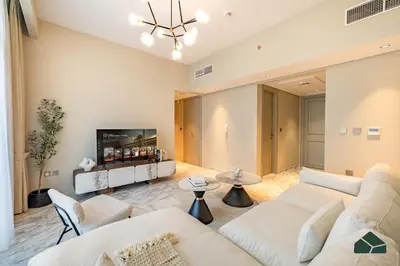 a living room with two white couches and a tv at Chic 1BR, Next to Metro by BMS in Dubai