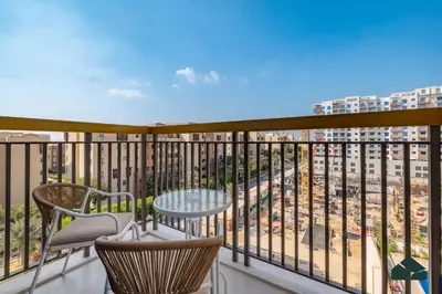 a balcony with a table and chairs and a view at Chic 1BR, Next to Metro by BMS in Dubai