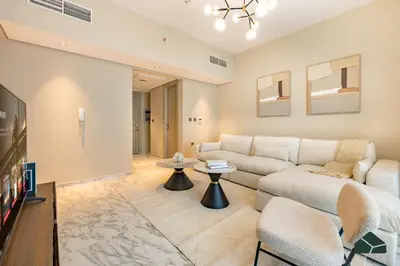 a living room with a couch and a tv at Chic 1BR, Next to Metro by BMS in Dubai