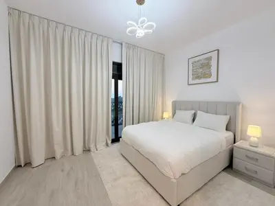 a white bedroom with a bed and a window at Stunning 3BR Retreat with Panoramic Sunset Views in Dubai