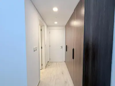 a hallway with a white door and a wooden floor at Stunning 3BR Retreat with Panoramic Sunset Views in Dubai