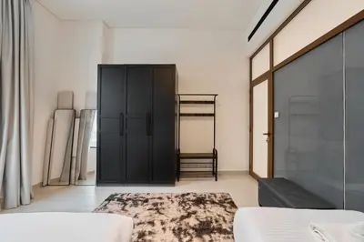 a bedroom with a black cabinet and a rug at Elegant 2BR Ground Floor Escape in Binghatti Galaxy JVC in Dubai