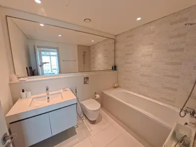 a bathroom with a sink and a tub and a toilet at Orange Plumeria 1701 - 2BR SeaView with Prvt Beach in Dubai