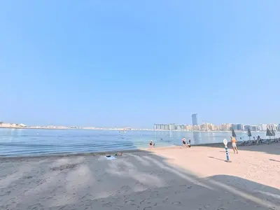 a group of people on a beach near the water at Orange Plumeria 1701 - 2BR SeaView with Prvt Beach in Dubai