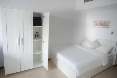 a white bedroom with a bed and a closet at Sunsand Studio at Dubai Marina in Dubai