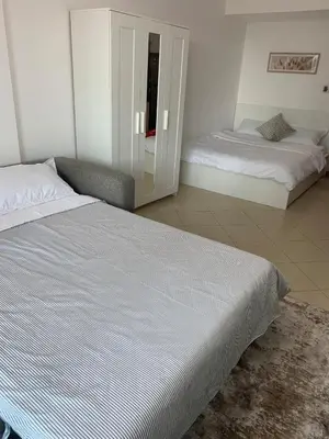 a bedroom with two beds and a mirror at Sunsand Studio at Dubai Marina in Dubai