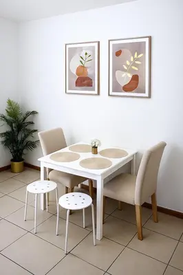 a white dining room table and chairs with paintings on the wall at Sunsand Studio at Dubai Marina in Dubai