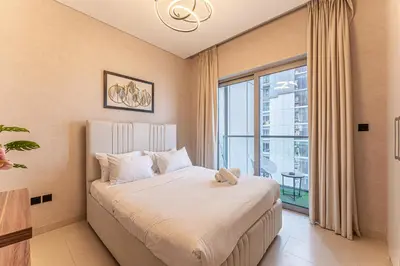 a bedroom with a bed and a large window at HAVN - 1 bedroom in Sobha Creek, MBR City in Dubai