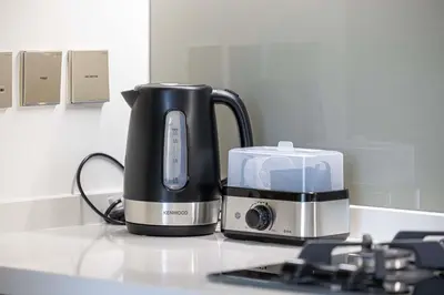 a black coffee maker and a toaster on a counter at LUX 1 BDR apartment Downtown - Burj Khalifa view in Dubai