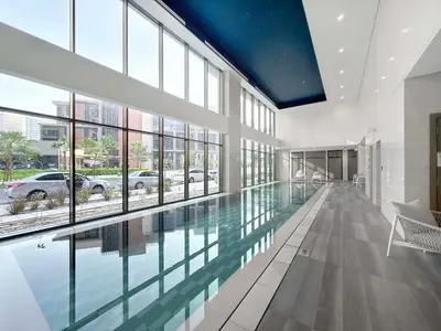 a swimming pool in a building with glass windows at LUX 1 BDR apartment Downtown - Burj Khalifa view in Dubai