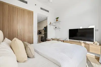 a bedroom with a large bed with a flat screen tv at Bright Modern Studio in Meydan Azizi Riviera 40 in Dubai