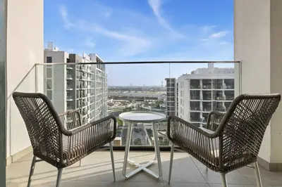 two chairs and a table on a balcony with a view at Bright Modern Studio in Meydan Azizi Riviera 40 in Dubai
