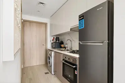 a kitchen with a stainless steel refrigerator and a dishwasher at Bright Modern Studio in Meydan Azizi Riviera 40 in Dubai