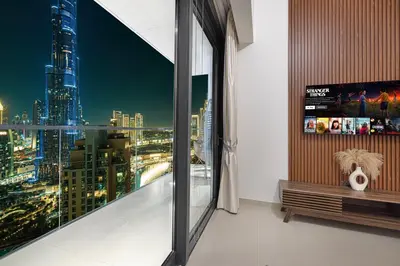 a room with a view of a city at night at Luxury Downtown 2 Bedroom Apartment with amazing Burj and Fountain Views and Private Jacuzzi on a large Terrace in Dubai