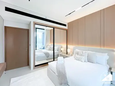 a bedroom with a large white bed and a mirror at 2BR Panoramic Skyline Haven with Jacuzzi in Dubai