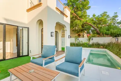 an outdoor patio with two chairs and a pool at Cozy 2Bedroom Villa with Private Pool in Springs in Dubai