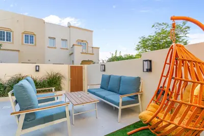 a patio with two chairs and a swing at Cozy 2Bedroom Villa with Private Pool in Springs in Dubai