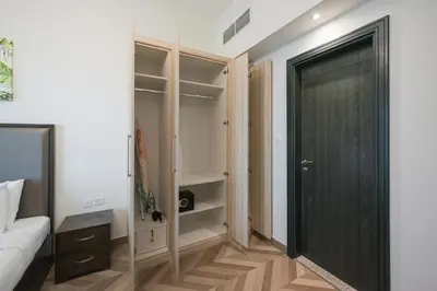 a bedroom with a closet with a black door at Spacious apt City view Gym and pool in Dubai