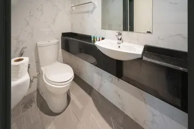 a bathroom with a white toilet and a sink at Spacious apt City view Gym and pool in Dubai
