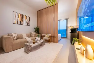 a living room with a couch and a flat screen tv at Exquisite Studio by UDH Sway Residence at Dubai Hills in Dubai