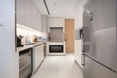 a kitchen with white cabinets and stainless steel appliances at Address Beach Resort 3 Bedroom with Sea and Palm Views in Dubai