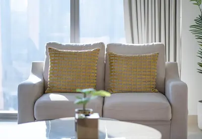 a living room with a couch with yellow pillows at Luxury 2 Bed in Boulevard Point with City Views in Dubai