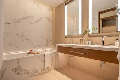 a bathroom with a tub and a sink and a mirror at Frank Porter - Address Residences Dubai Opera Tower 1 in Dubai