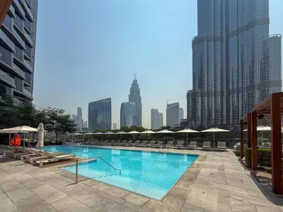 a large pool with chairs and umbrellas in a city at Frank Porter - Address Residences Dubai Opera Tower 1 in Dubai