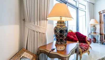 a living room with a lamp on a table at Elegant 3 BR plus Maids Infinity Pool Burj View in Dubai