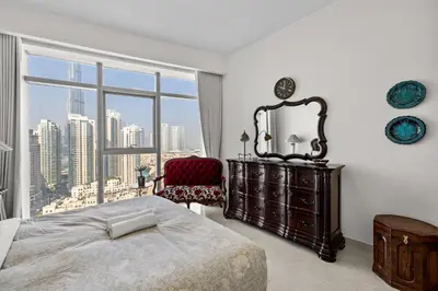 a bedroom with a bed and a large window at Elegant 3 BR plus Maids Infinity Pool Burj View in Dubai
