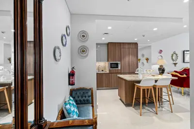 a kitchen and living room with a table and chairs at Elegant 3 BR plus Maids Infinity Pool Burj View in Dubai